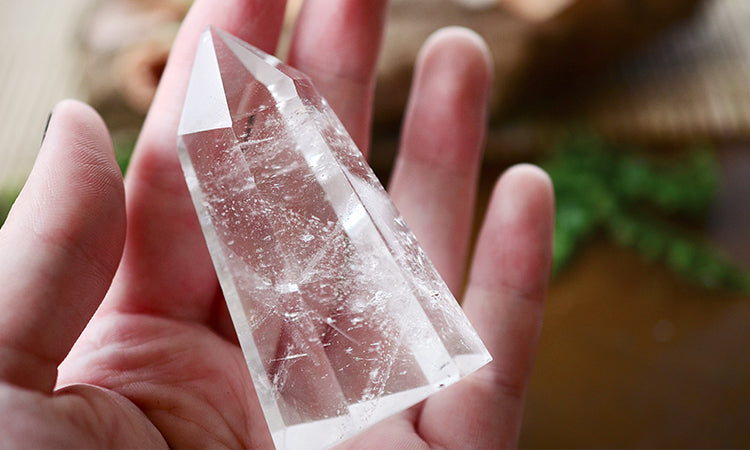 Clear quartz healing crystal in palm